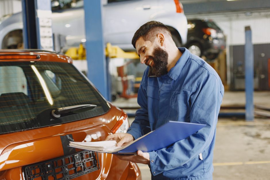 Auto mechanic inspecting vehicle